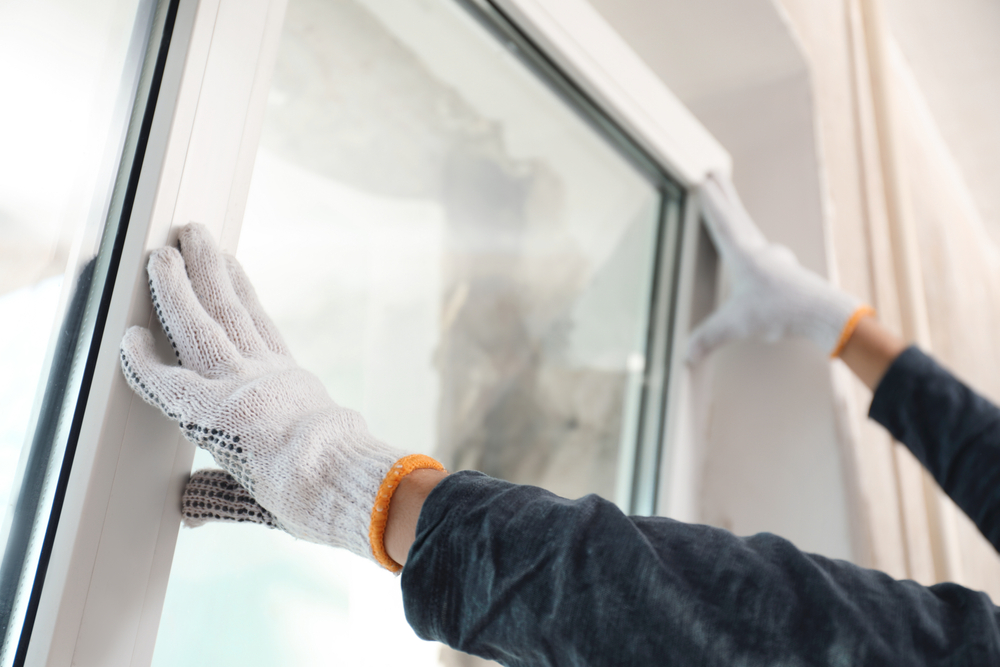 Travailleur installant une fen&ecirc;tre en plastique &agrave; l'int&eacute;rieur, vue en gros plan