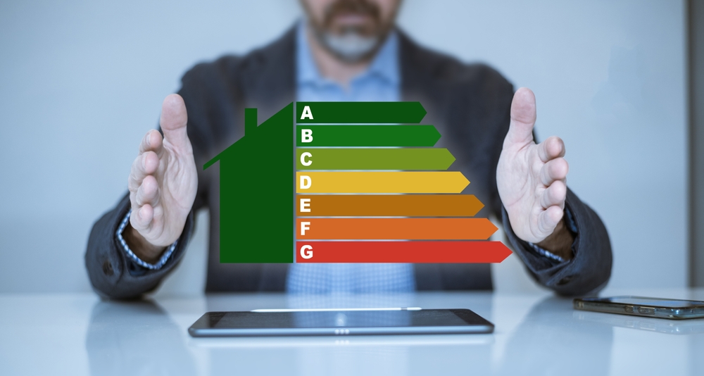 Focus sur la rénovation énergétique avec RSM Rénovation Homme calculant la classe d'efficacité énergétique des bâtiments. Concept de maison écologique et bio-énergétique.